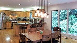 A modern kitchen with wooden cabinets, stainless steel appliances, and a large island with seating.