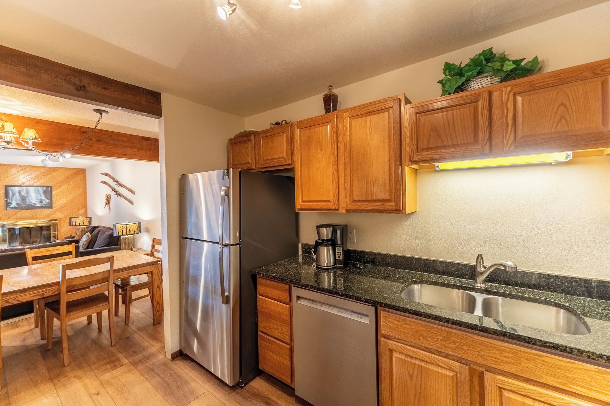 A modern kitchen with wooden cabinets, stainless steel appliances, and a granite countertop.