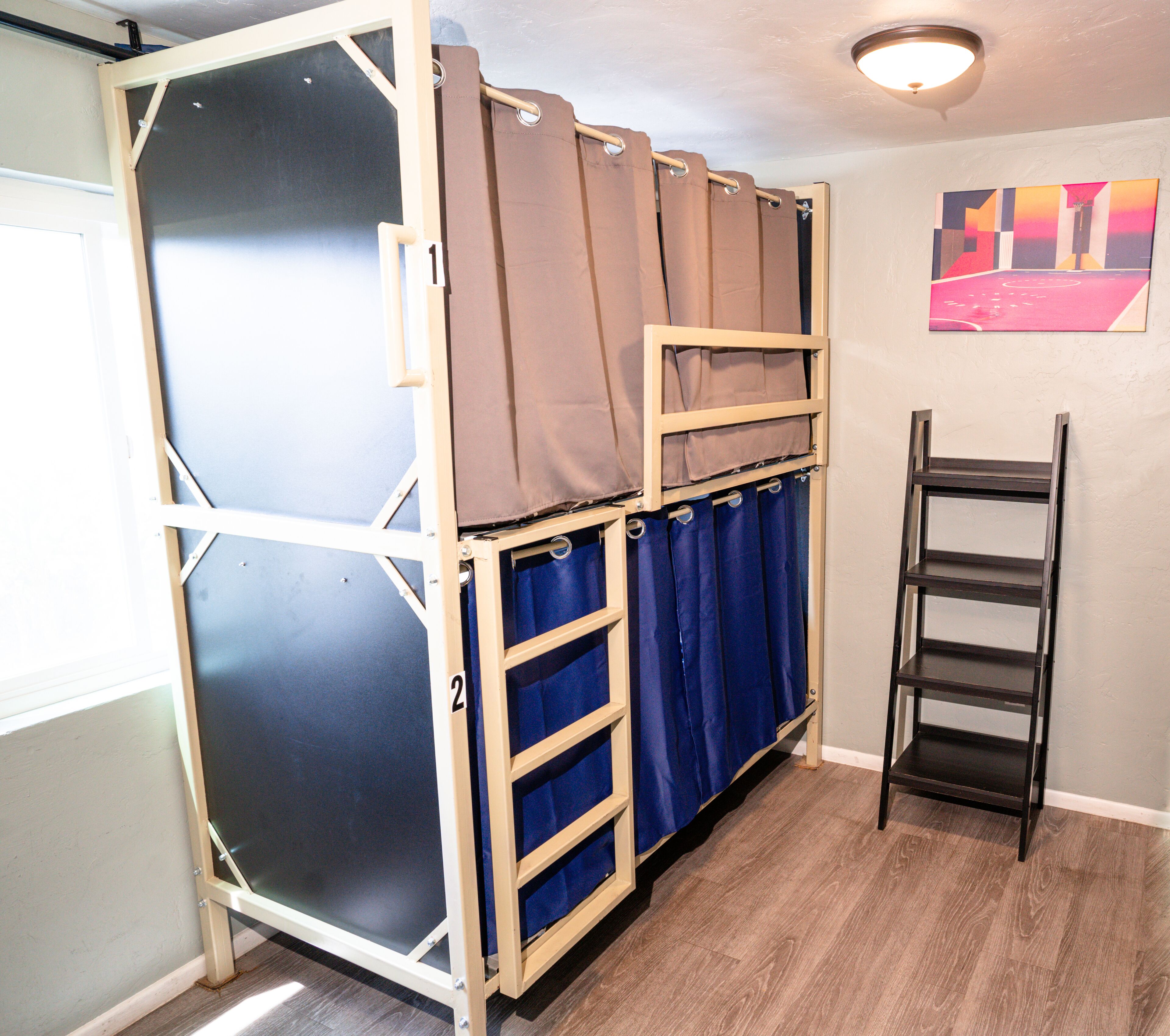 A room with a bunk bed, a ladder, and a door.