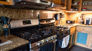 Una cocina con estufa, horno y lavavajillas de acero inoxidable.