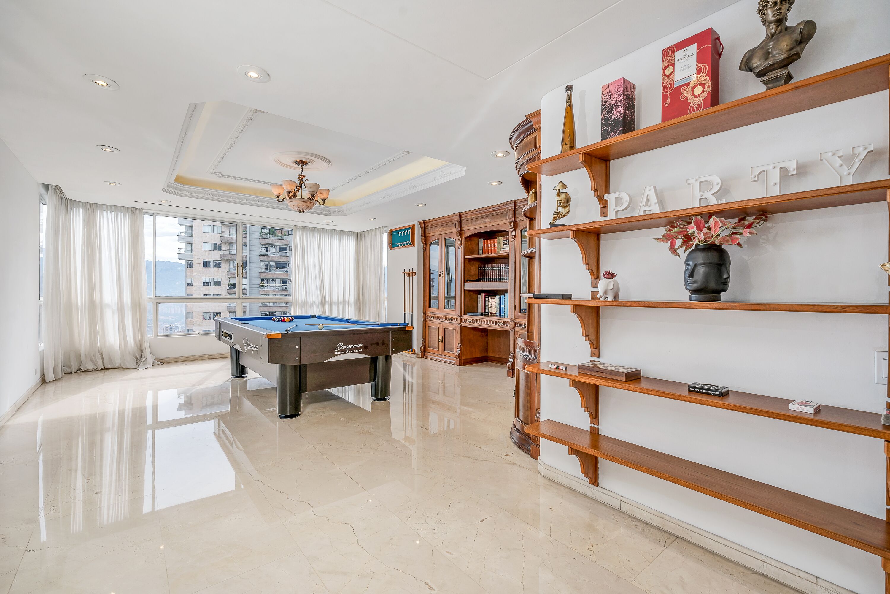 A modern living room with a pool table, a bookshelf, and a 'PARTY' sign.