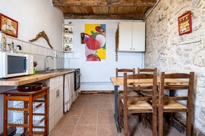 Une cuisine équipée d’un four à micro-ondes, d’un évier et de chaises en bois.