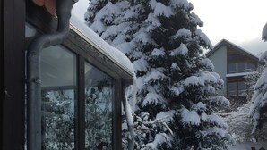 Um edifício com grandes janelas e fachada coberta de neve.