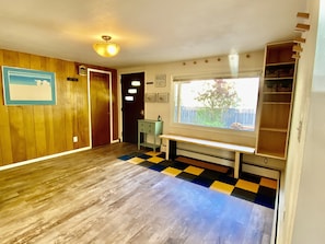 Enjoy a peaceful retreat with a window view of lush greenery and a comfortable space featuring a wooden floor and a convenient cabinet.
