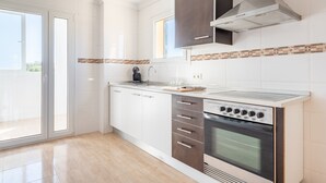 A modern kitchen with a built-in oven, a coffee maker, and a window. - Apartment "Ferrera Soul 2B" near the beach with Wi-Fi and terrace (tourist taxes included) (Santanyí)