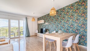 A modern living room with a dining area, large windows, and a patterned wall. - Apartment "Ferrera Soul 2B" near the beach with Wi-Fi and terrace (tourist taxes included) (Santanyí)