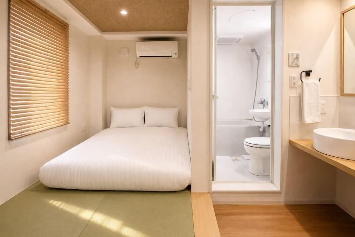 A compact room with a bed, a toilet, and a sink.