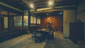 Een traditionele Japanse kamer met tatami vloerbedekking, een lage tafel met kussens en shoji schermen.