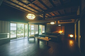 Een traditionele Japanse kamer met tatami vloerbedekking, een lage houten tafel en een bank.