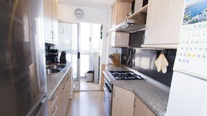 Une cuisine moderne dotée d’appareils électroménagers en acier inoxydable, de meubles en bois et d’un calendrier accroché au mur.
