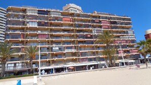 A multi-story hotel with balconies, a beachside location, and palm trees. - A38 CALPEMAR B 2º - 5 (Calpe / Calp)