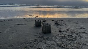 A beach with sand and waves, and a sunset in the background. - 2 Bedroom Vintage Beach Bungalow steps to downtown Rockaway and Rockaway Beach (Rockaway Beach)