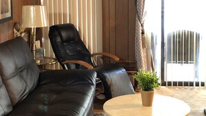 Un salón acogedor con un sofá de cuero, una mesa de centro de madera y una planta en maceta.