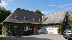A house with a sloped roof, a chimney, and a garage.