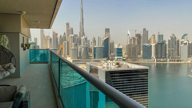 A balcony with a city view, including a prominent skyscraper. - HiGuests - Elite Business Bay (Dubai)