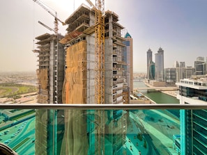 A high-rise building under construction with a view of a cityscape and a river.