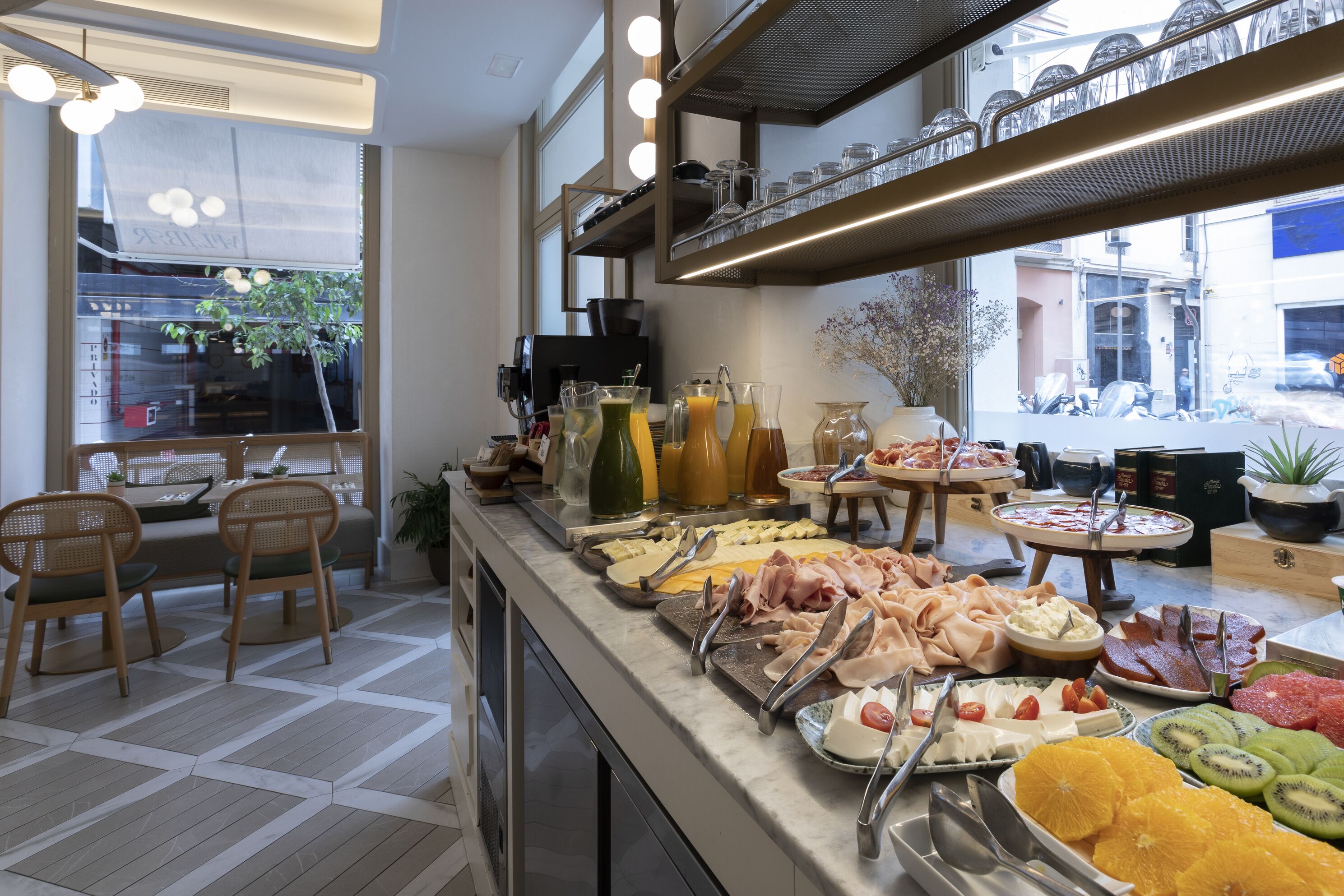 Un montaje tipo bufé con diversas opciones de comida y una zona de estar con sillas y una mesa.