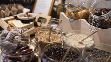 Diversos alimentos en frascos de vidrio, como nueces, semillas y frutas deshidratadas.