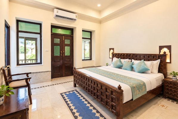 A bedroom with a wooden bed, a nightstand, a chair, a window, and a door.