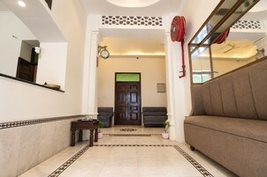 Una sala de estar con un sofá, una mesa de centro y una chimenea. Hay una puerta que da a otra habitación y una ventana con vistas.
