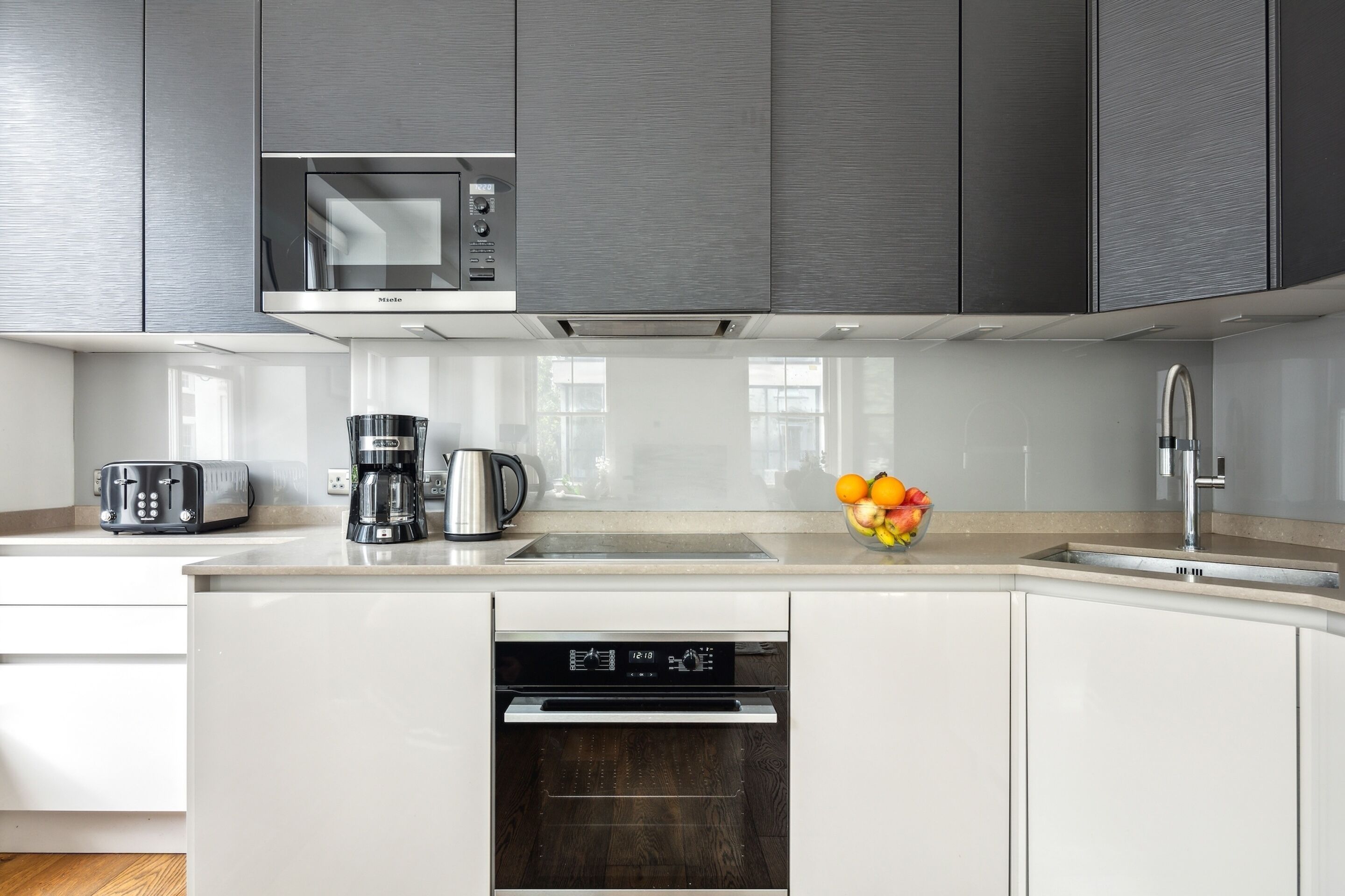 Una cocina moderna con microondas integrado, cafetera, tostadora y lavavajillas.