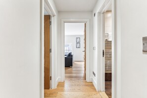 Stylish hallway leading to a cozy room with a sofa and window.