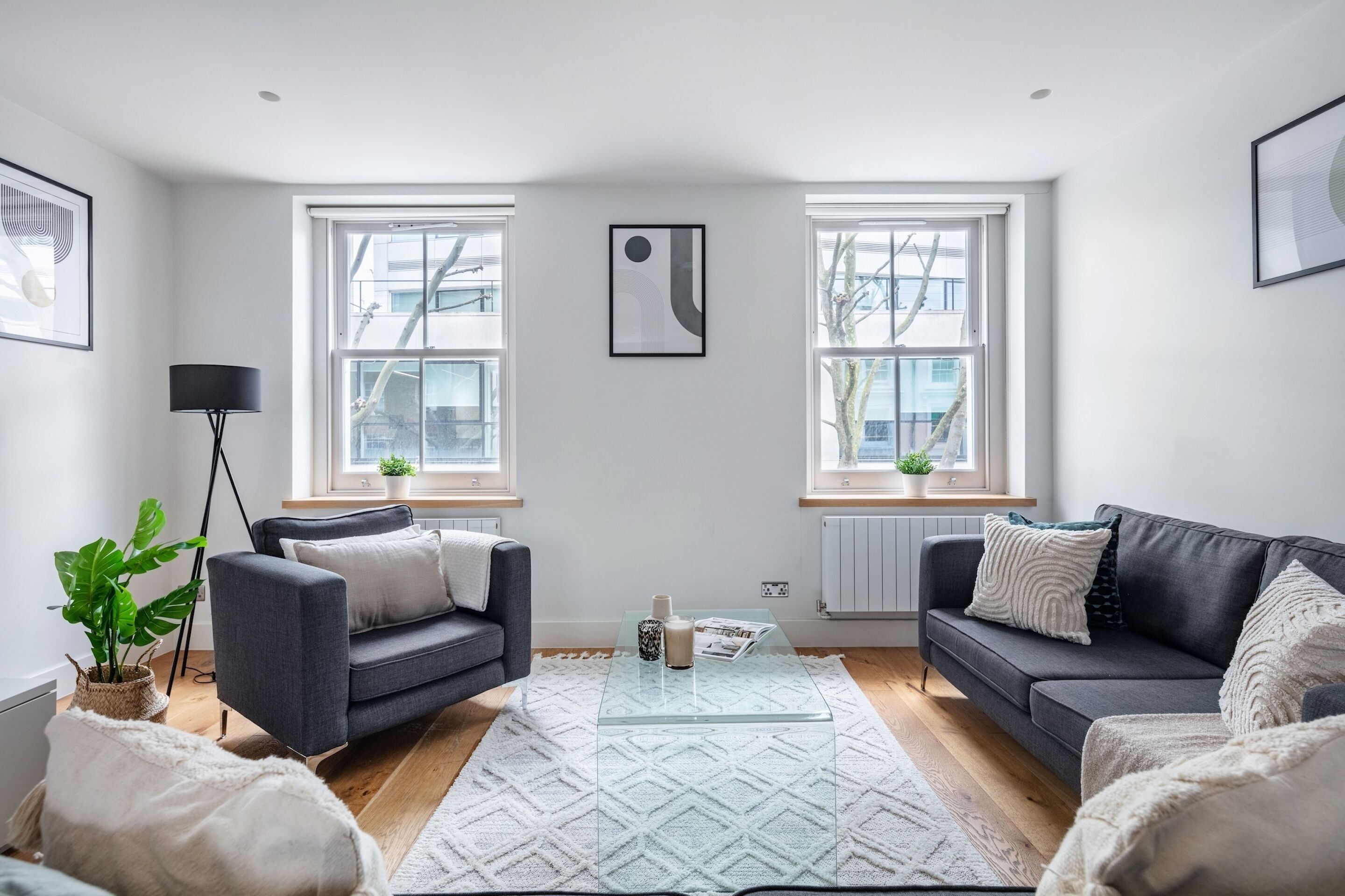 A modern living room with two sofas, a coffee table, and a floor lamp.