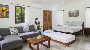 Un dormitorio moderno con cama, sofá, mesa de centro y armario.