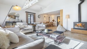Un salón comedor amplio con techo alto y chimenea.