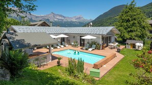 Un resort con piscina, mobiliario exterior y vistas a la montaña.