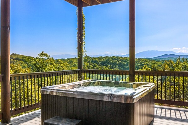 A hot tub on a wooden deck with a view of a forest and mountains. - Paradise Mountain Retreat - Theater Room, Indoor Pool, Wi-Fi & Pool Table (Sevierville)