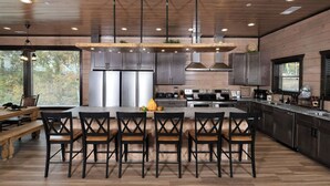 Una cocina moderna con una isla central, electrodomésticos de acero inoxidable y suelo de madera.
