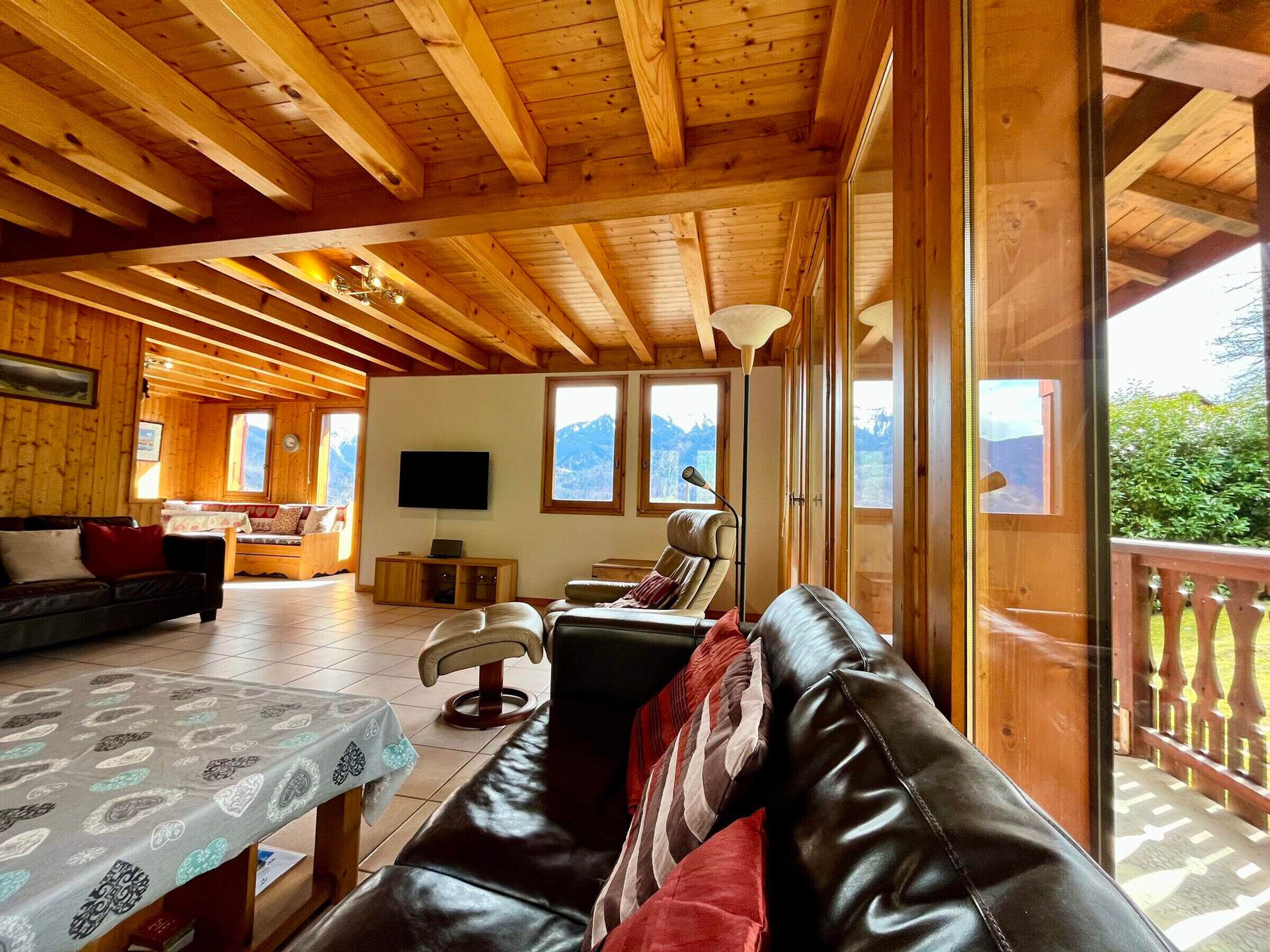 Ein gemütliches Holzhaus-Interieur mit Wohnzimmer, Essbereich und Bergblick.