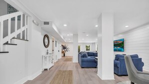Una sala de estar moderna con un sofá azul, una consola blanca y un cuadro en la pared.