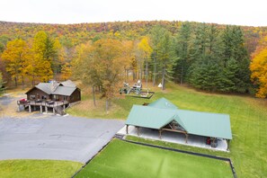 A lodge with a large parking area, a covered picnic area, and a view of a forested hillside. - A quiet, outback setting, nestled in the mountains of Snyder County (Milroy)