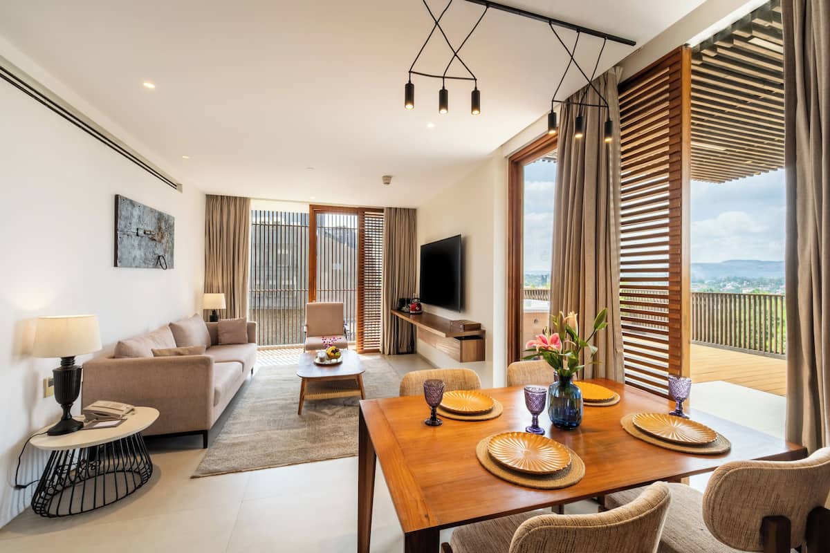A modern living room with a sofa, dining table, and TV.