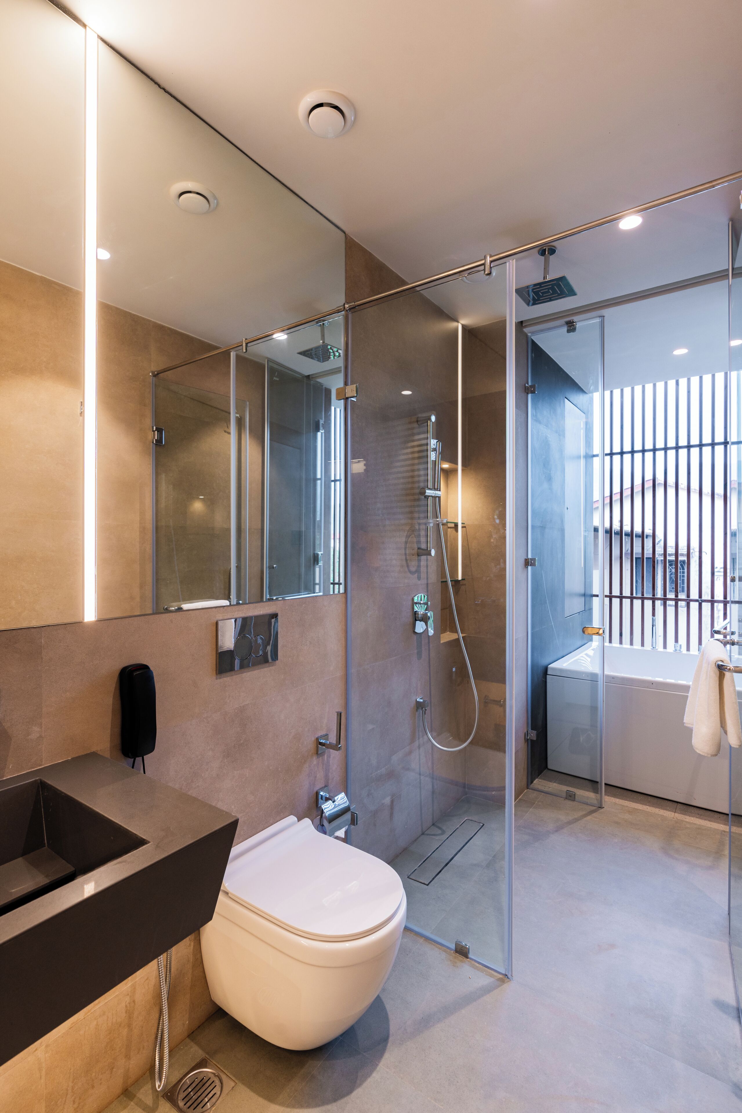 A modern bathroom with a glass shower enclosure, a toilet, a sink, and a bathtub.