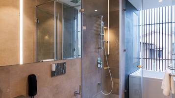 A modern bathroom with a glass shower enclosure, a toilet, a sink, and a bathtub.
