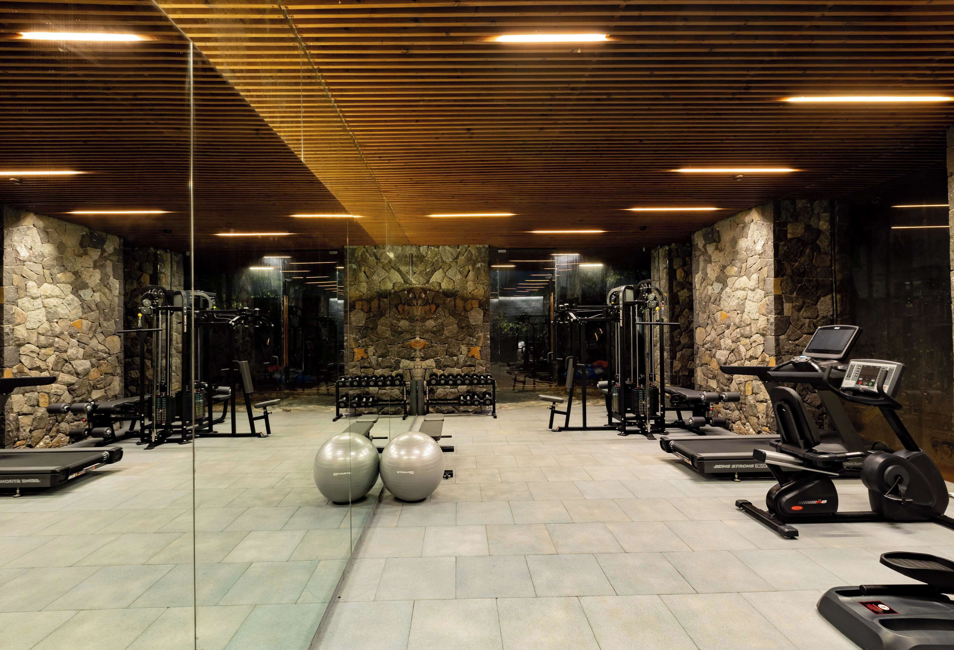A gym with treadmills, elliptical machines, and stationary bikes.