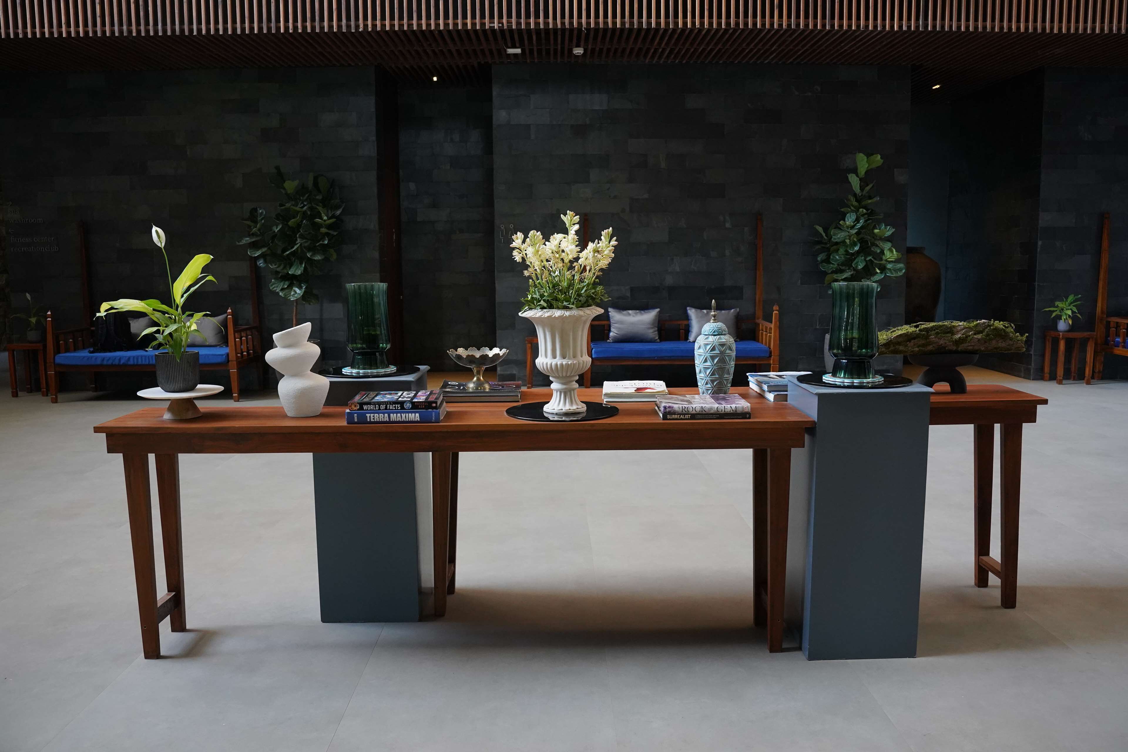 A reception area with a wooden reception desk, potted plants, and seating areas.