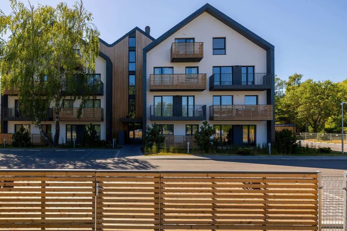 Un moderno edificio residencial de varios pisos, con balcones y ventanas amplias.