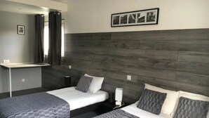 A hotel room with two beds, a desk, and a mirror. - Hotel Mervil Airport (Merville)