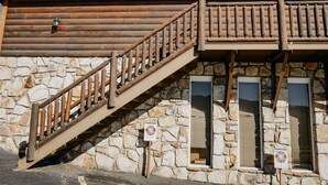 A stone building with a wooden staircase and a wooden balcony.