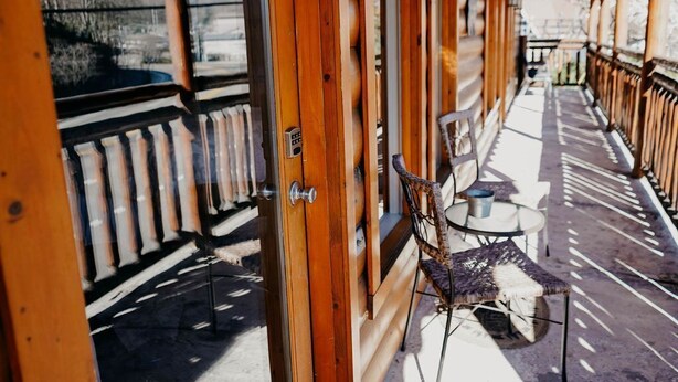 A corridor with wooden paneling, a door with a keypad lock, and a chair with a cushion.