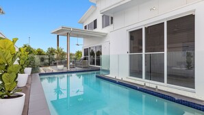 A modern house with a swimming pool, large windows, and outdoor seating. - Sunrise Mansion with Pool - 6 bedrooms (KINGSCLIFF)