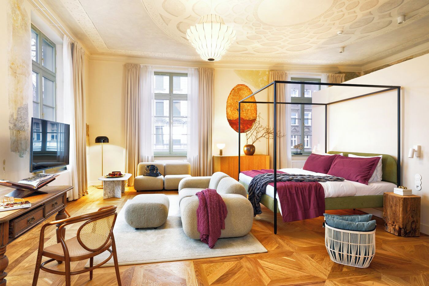 Un dormitorio moderno con una cama con dosel, televisión y un ventanal grande.