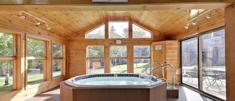 Una cabaña de madera con jacuzzi, ventanas amplias y un cartel que prohíbe el consumo de alcohol.