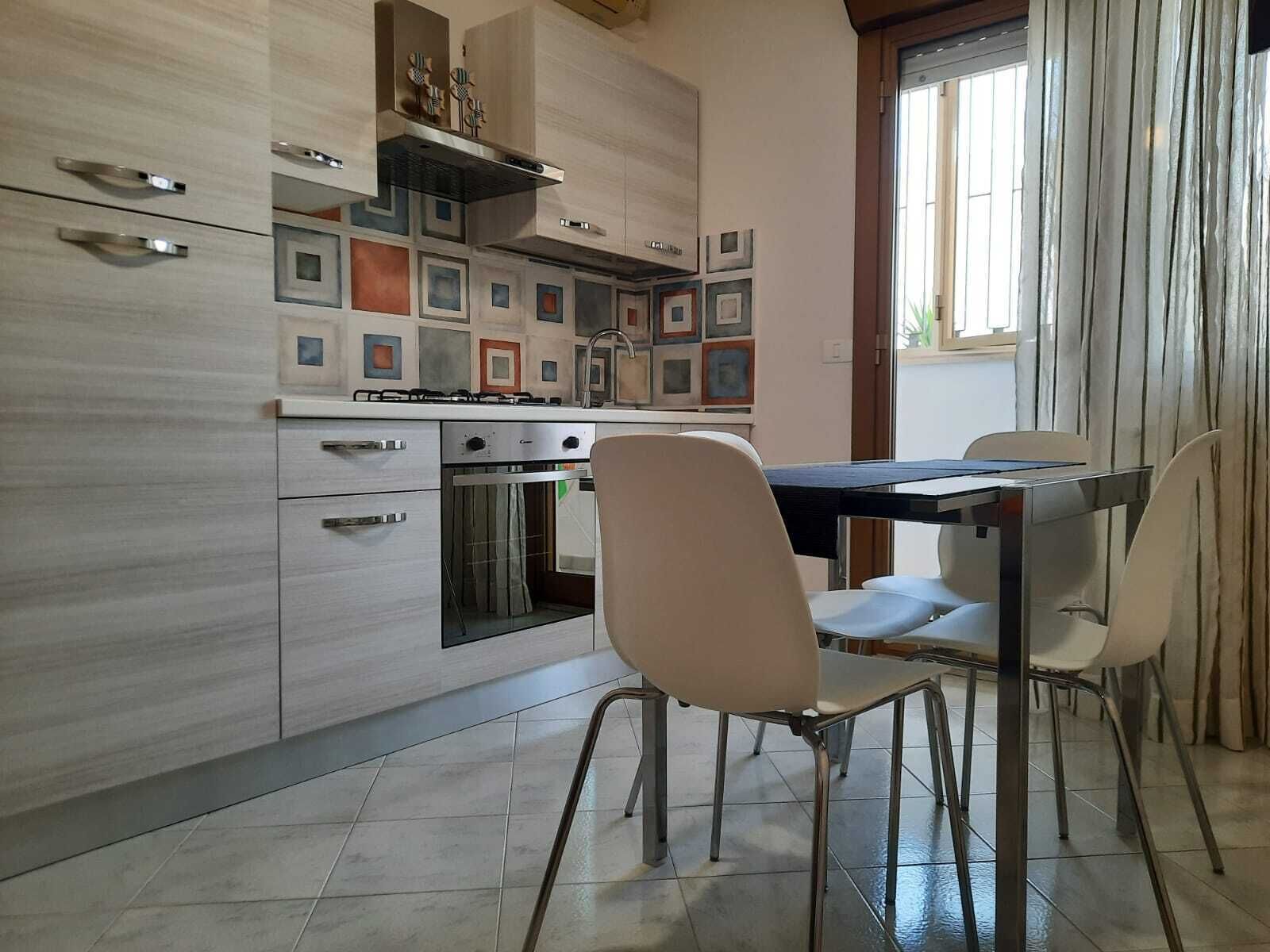 Une cuisine moderne avec un coin repas, comprenant une cuisinière, un four et une table avec des chaises.