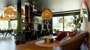 A modern interior with a round table, green chairs, and hanging wicker lamps. - Rioca Munich Posto 3 (Munich)