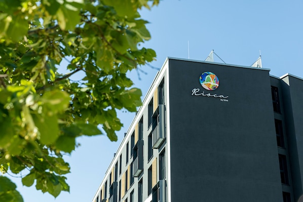 A building with a logo and the name "Rioca by Live" on its facade.